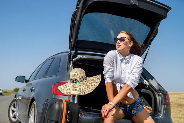 sexy hermosa modelo europeo en vacaciones de verano y gafas de sol posando en auto de lujo en la naturaleza en el paisaje de verano
. - Foto, imagen