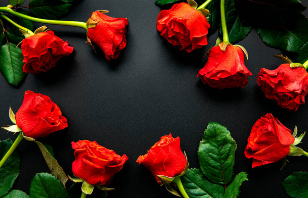 Red roses, concept of valentine day on a black background, top view. - Fotó, kép