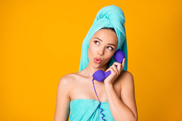 Portrait of attractive lady speak old phone look empty space teal towel isolated on yellow color background - Valokuva, kuva