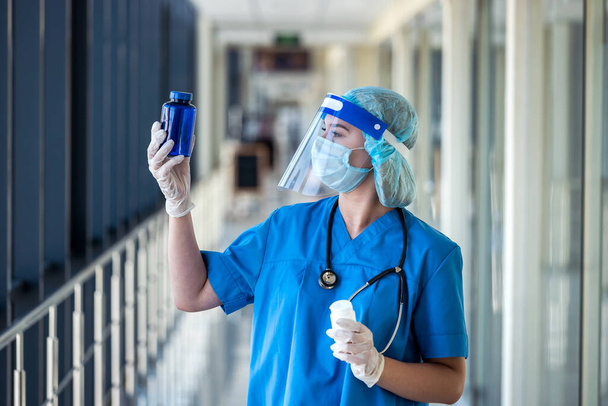 Doctora en uniforme sosteniendo pastillas en la clínica. concepto médico - Foto, Imagen
