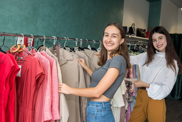 İki arkadaş canlısı kız moda mağazasında alışveriş yapmak için zaman geçiriyorlar. Yaşam biçimi - Fotoğraf, Görsel