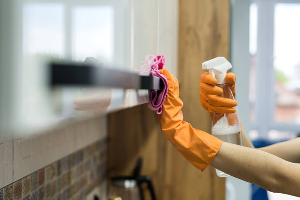 mulher em luvas de borracha e limpar o balcão da cozinha com esponja. trabalhos domésticos - Foto, Imagem