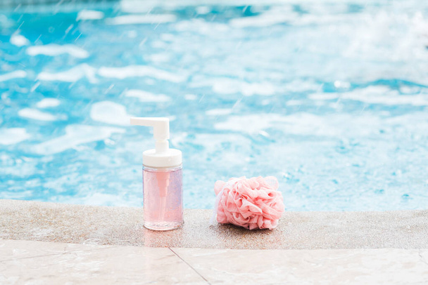 Une bouteille de gel douche rose et une éponge filet douche - Photo, image