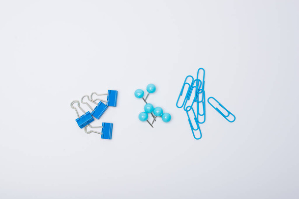 different blue clips paper on white background - Zdjęcie, obraz