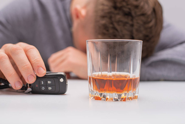 do not drink and drive concept, man with a remote car key and a glass of bourbon whiskey - Фото, зображення