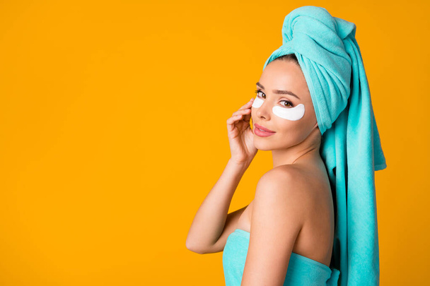 Side profile photo of young beautiful smiling woman girl look in camera apply eye patch isolated on yellow color background - Φωτογραφία, εικόνα