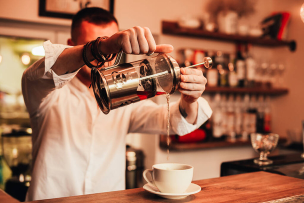 barista pouring coffee into glass at cafe - Zdjęcie, obraz