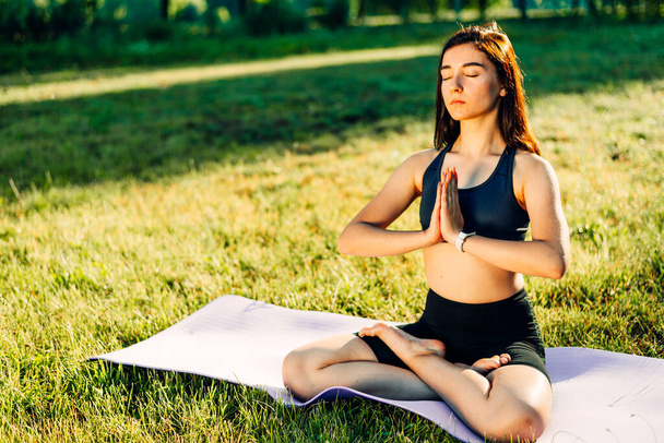 girl practices yoga outdoors in the morning at sunrise - Photo, image