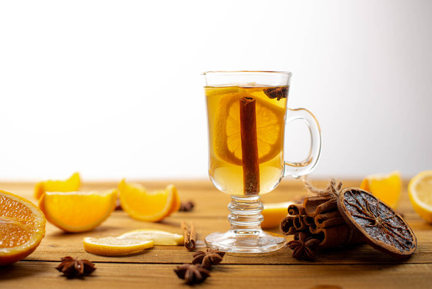 Tasty tea drink with cinnamon and anise stars  in glass on table - Foto, Imagen