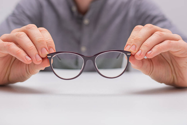 Male hands holding a pair of glasses - Photo, Image