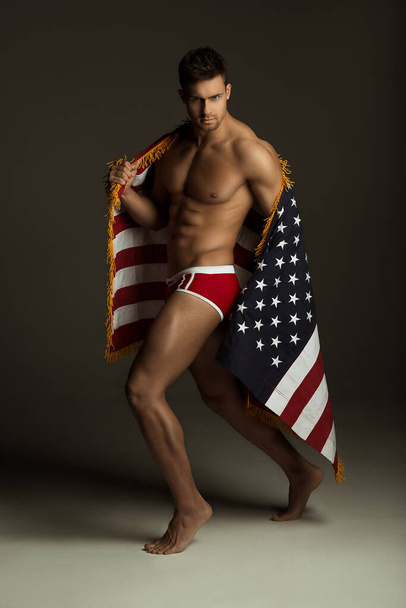 Fitness man in red underwear with american flag - Fotó, kép