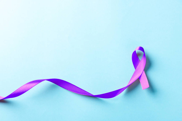 National Epilepsy or Alzheimer disease Day Concept. Purple ribbon symbol of Pancreatic cancer awareness and world Lupus Day and world cancer isolated blue background - Фото, зображення