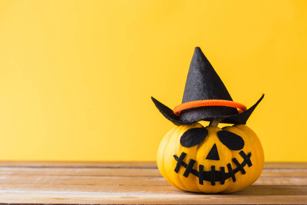Funny Halloween day decoration party, closeup halloween pumpkin head jack o lantern smile scary on wooden and copy space, studio shot isolated yellow background, Happy holiday concept - Photo, image