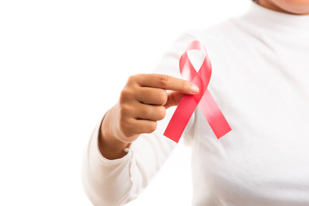 Woman holding HIV AIDS awareness red ribbon in studio shot isolated on over white background, Healthcare and medicine, World aids day concept - Valokuva, kuva