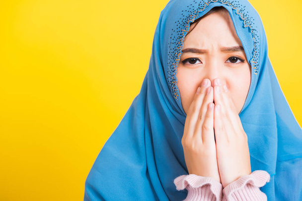 Asian Muslim Arab, Portrait of happy beautiful young woman religious wear veil hijab she sad crying using hand wiping tears in her eyes, studio shot isolated on yellow background with copy space - Foto, imagen