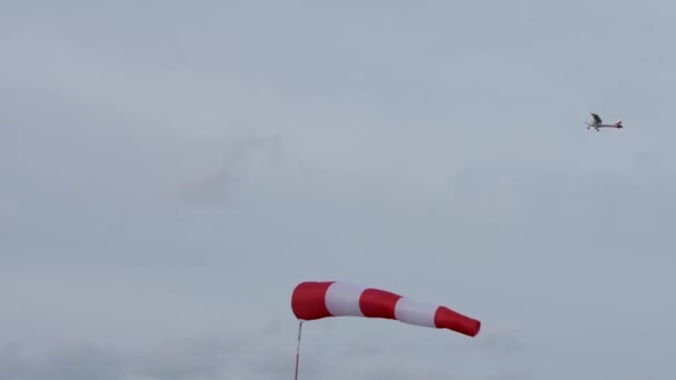 Красный одномоторный самолет пролетает над ветром. - Кадры, видео