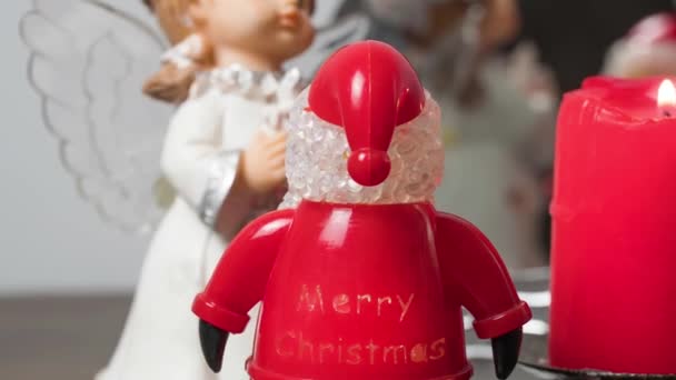 Angelo con Babbo Natale e candele rosse accese a Natale o Capodanno. Vacanze e vacanze di dicembre - Filmati, video