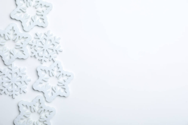 Beautiful decorative snowflakes on white background, flat lay. Space for text - Valokuva, kuva