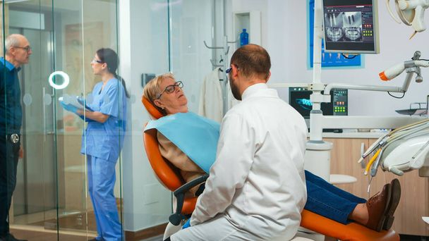 Kieferorthopäde spricht mit Patienten mit Zahnschmerzen - Foto, Bild