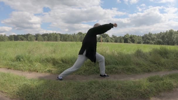 Člověk bojuje s imaginárním protivníkem ve stylu Wushu pěsti velkého limitu - Záběry, video