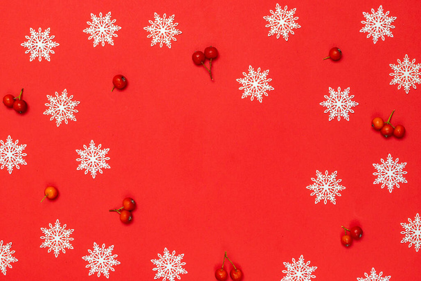 Banner de invierno. Baya roja, copos de nieve blancos en forma de marco sobre fondo rojo para tarjeta de felicitación. Navidad, invierno, concepto de año nuevo - Foto, imagen