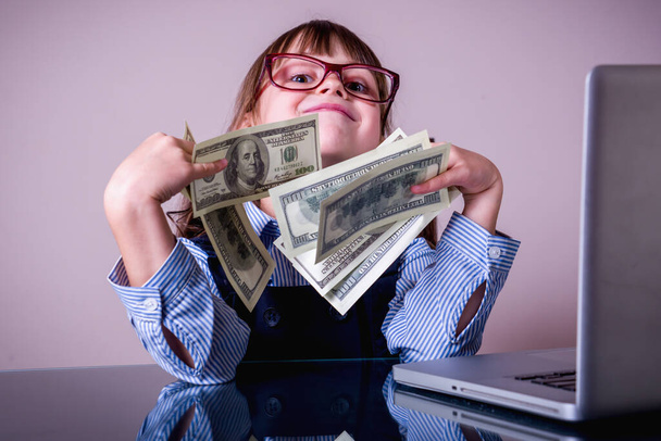 Деньги лучшая мотивация. Молодая красивая девочка держит банкноты в долларах США.  - Фото, изображение