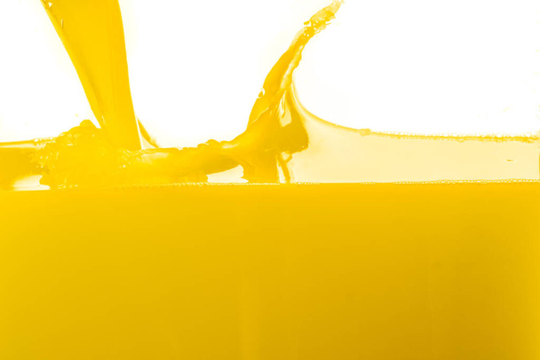 Orange juice splashing against white background. - Photo, Image