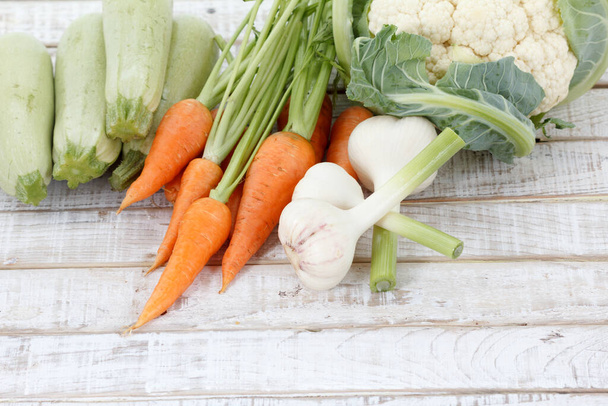 Φρέσκα λαχανικά σε ξύλινο φόντο, Καρότα, σκόρδο. - Φωτογραφία, εικόνα