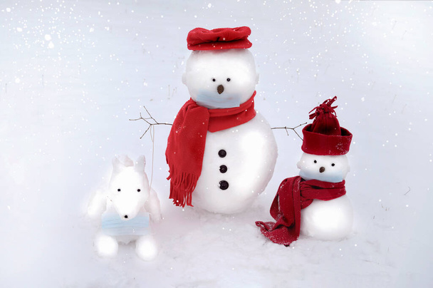Snowmen and dog wearing a face mask on a white winter background. - Фото, изображение