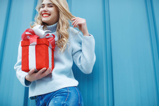 Krásná elegantní mladá blondýna drží dárkovou krabici. Vánoční fotky, dárky. - Fotografie, Obrázek