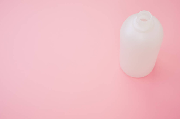 A closeup shot of a plastic bottle on a pink background - Foto, imagen