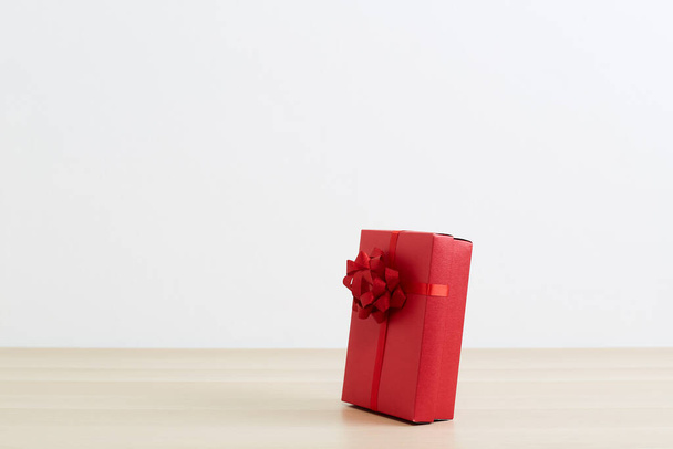 Karácsonyi ajándékok Piros ajándék doboz a fapadlón Boldog Karácsonyt és Boldog Új Évet - Fotó, kép