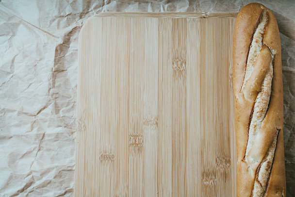Traditional French baguette over wooden and paper background. Sustainability zero waste concept. Flat lay. Top View - Photo, Image
