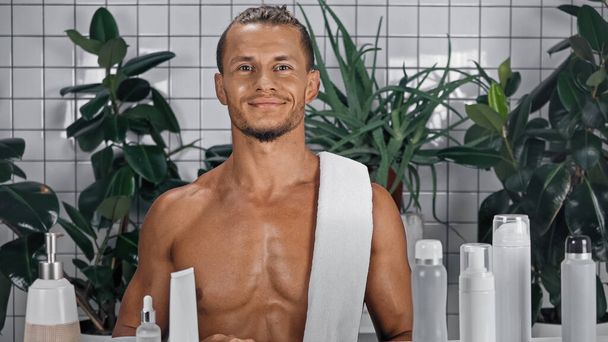 happy and shirtless man near green plants on blurred background in bathroom  - Photo, Image
