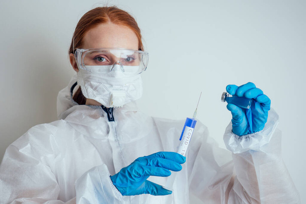 virologist woman in chemical protection mask ,glasses and gloves holding potential vaccine at the lab - Zdjęcie, obraz