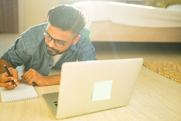 distance home learning concept indian male doing home work in living room business start up - Fotoğraf, Görsel