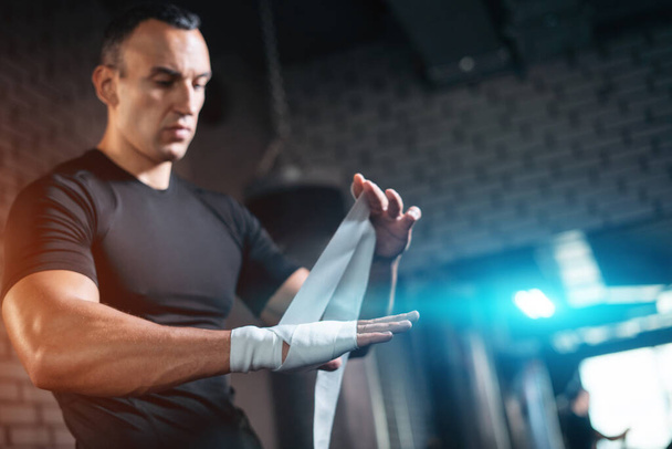 athletic boxer man bandage hand and preparing for training or fighting in gym - Zdjęcie, obraz