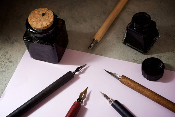 Nib pens for calligraphy and inkwells on a table. - Photo, Image