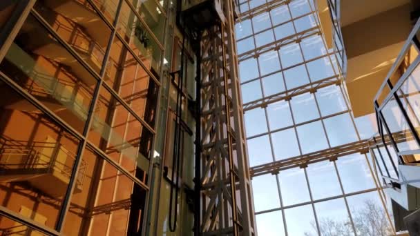 Günbatımında golsen saatinde modern şirket binasında hızlandırılmış asansör hareket ediyor. - Video, Çekim