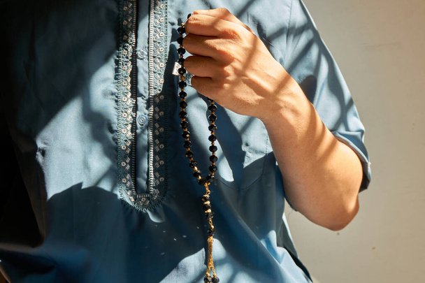 Muszlim férfi kezében fekete színű imagyöngyök ima közben - Fotó, kép