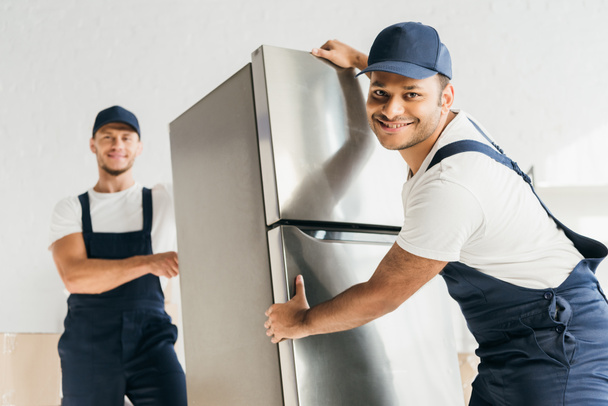 Веселі індіанці в одноманітному холодильнику біля співробітника на розмитому фоні.  - Фото, зображення