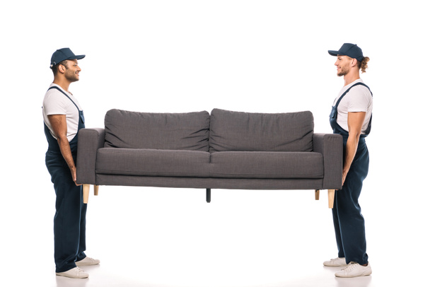 longitud completa de feliz multicultural movers llevando sofá en blanco  - Foto, Imagen
