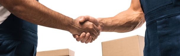 cropped view of movers shaking hands near boxes isolated on white, banner - Photo, Image