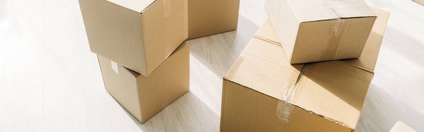 stacked carton boxes on floor in modern apartment, banner - Photo, Image