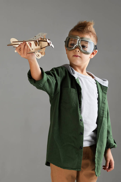 happy child boy playing with wooden toy airplane. dream - Φωτογραφία, εικόνα