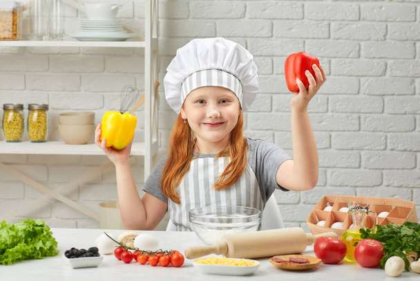 child holding yellow and red bell peppers - Photo, image