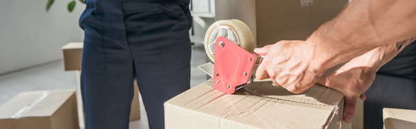 cropped view of mover packing box while coworker on blurred background, banner - Photo, Image