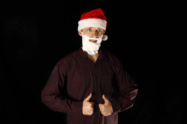 Santa hombre con una barba de espuma de afeitar en una camisa que muestra gesto como - Foto, imagen