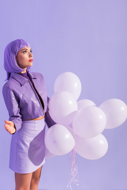 young woman dressed in doll style with balloons on violet colorful background - Photo, Image