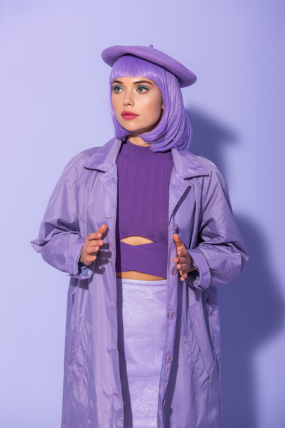 young woman dressed in doll style in beret posing on violet colorful background - Photo, Image